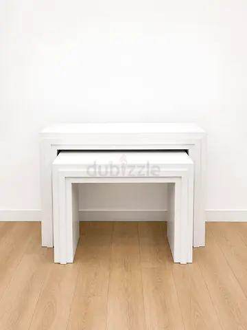 Set of 2 modern white nesting tables in good condition. Compact, practical, and perfect for small sp