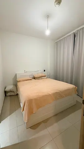 White wooden single bed frame with storage panels, without mattresses