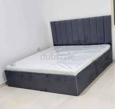 Grey upholstered double bed with headboard and storage base