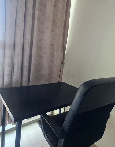 Simple black study desk with cushioned office chair
