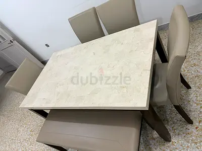 Marble-top dining table with 6 beige leather chairs