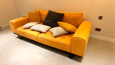 Comfortable mustard yellow sofa with accent cushions