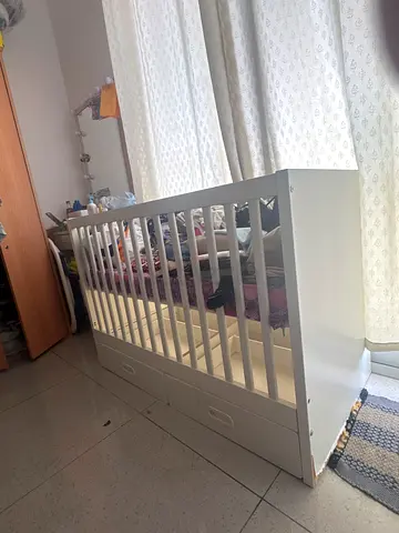 White wooden baby crib with built-in drawers - good condition