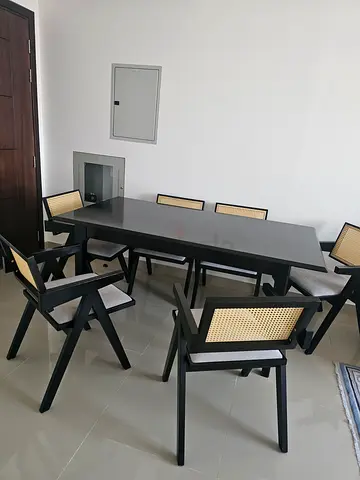 Dark wood dining table with 6 cane-back chairs - good condition