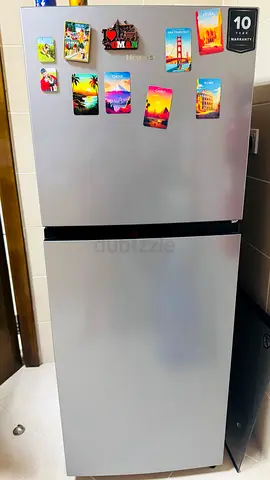 Silver top-freezer refrigerator - good condition, 10-year warranty sticker
