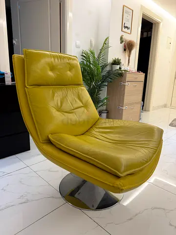 Green leather swivel lounge chair with chrome base