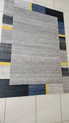 Gray geometric area rug with blue and yellow accents - good condition