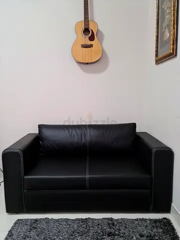 Black leather 2-seater sofa in good condition