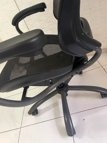 Used black ergonomic office chair with mesh back and armrests