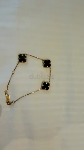 Gold-tone bracelet with four black clover motifs