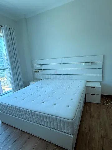 White double bed frame with mattress and bedside tables