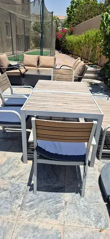 Outdoor dining table with 4 chairs and a bench and cushions