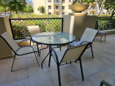 Outdoor glass-top dining table with 6 sling chairs — good condition