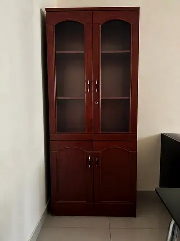 Tall wooden cabinet with glass display top and lockable storage
