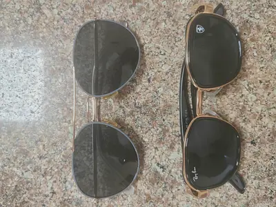 Two pairs of sunglasses — black vintage-style and Ray-Ban copy