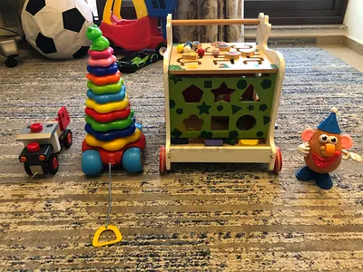 Wooden activity walker with shape sorter, stacking toy, pull car and Mr. Potato head - used
