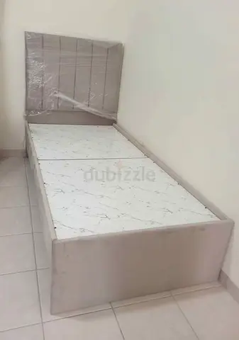 Single upholstered bed frame with marble-look base panels — good condition