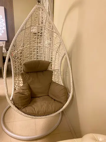 White rattan hanging egg chair with cushions