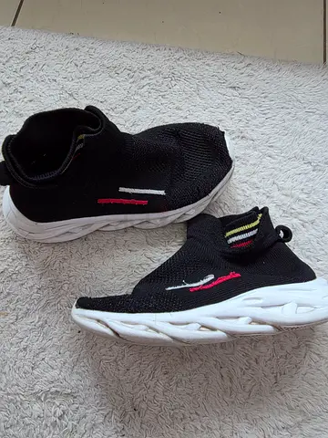Black slip-on knit sneakers with white sole, size 33, normal used.