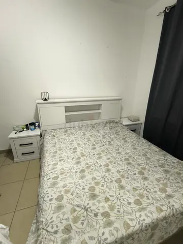 White wooden double bed frame with headboard and matching bedside tables