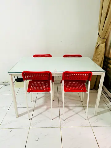 IKEA glass-top dining table with 4 red chairs - good condition
