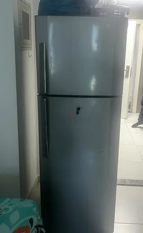 Used top-freezer refrigerator - good condition for AED 400