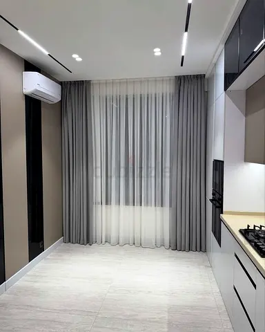 Light grey floor-to-ceiling curtains with sheer lining