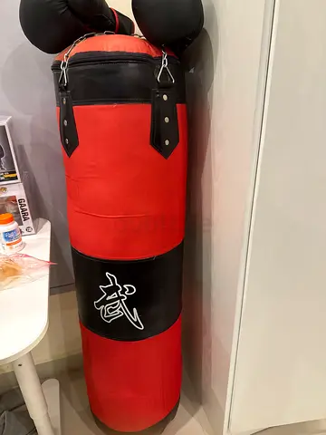Red hanging punching bag with gloves