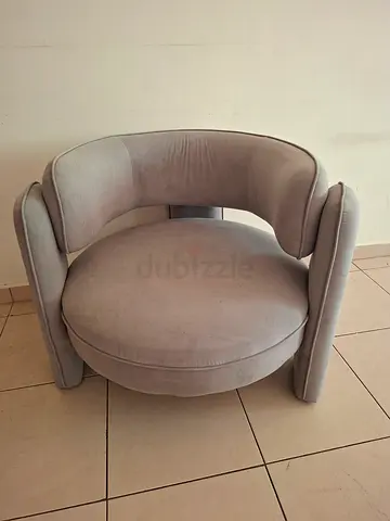 Round grey upholstered armchair with curved back