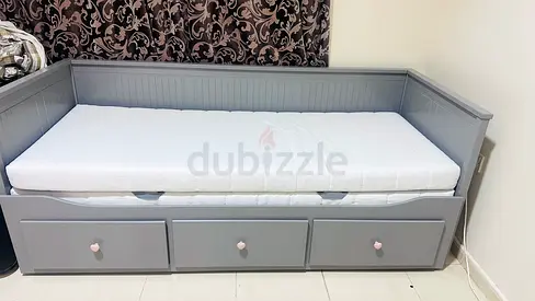 Grey wooden daybed with three storage drawers and mattress