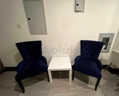 Pair of navy velvet accent chairs with small white side table