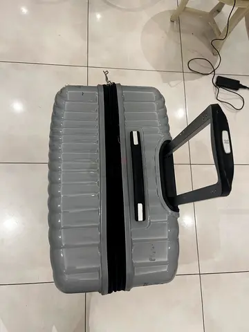 Silver hard-shell carry-on suitcase with telescopic handle