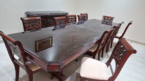 طاولة كبيرة من الخشب عليها زجاج حافظ مع 12 كرسي وطاولة بوفيه مع زجاج حافظ بـ4000