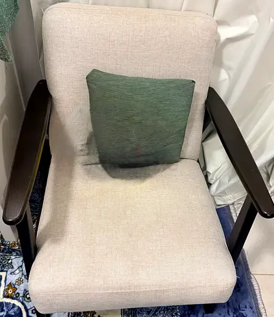 Light beige armchair with dark wooden arms — good condition
