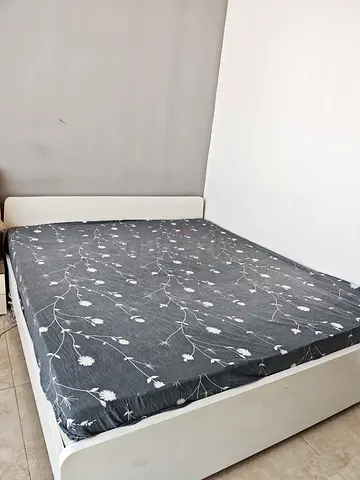 White minimalist bed frame with floral patterned mattress