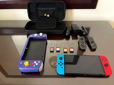 Nintendo switch oled (red and blue) with a nitro deck (purple) 3 games and case