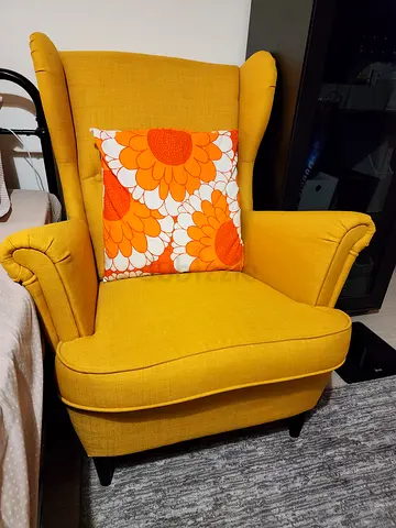 Comfortable Yellow Wingback Armchair with Floral Accent Pillow