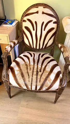 Vintage carved wooden armchair with zebra-pattern upholstery