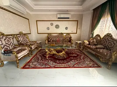Ornate gold-accented living room sofa set with matching rug