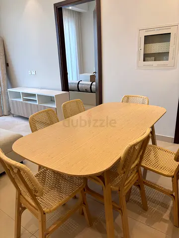 Light wood dining table with 6 woven cane chairs - good condition