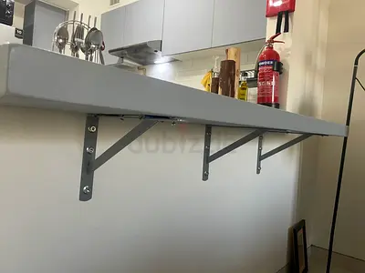 Wall-mounted kitchen shelf with metal brackets