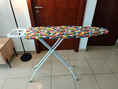 Standing ironing board with colorful cover, foldable and in good condition