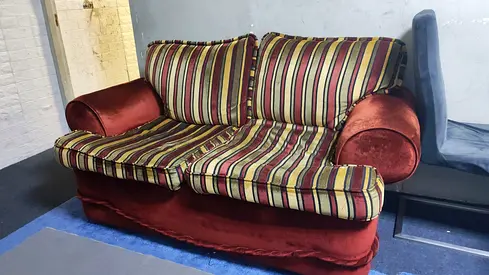Two-seater velvet sofa in red with striped cushions - used