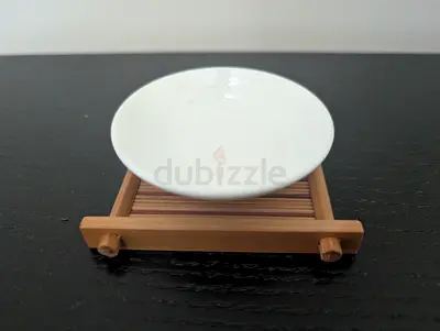 Small white ceramic saucer on bamboo coaster