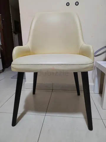 Cream faux-leather dining/occasional chair with black wooden legs