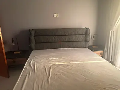 Queen bed frame with padded headboard and bedside tables