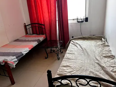 Two single metal beds (mattress included) with side table