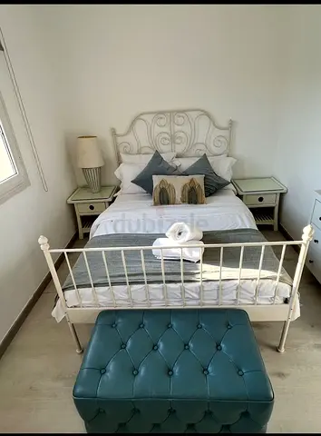 Bed, bedside tables, and poof