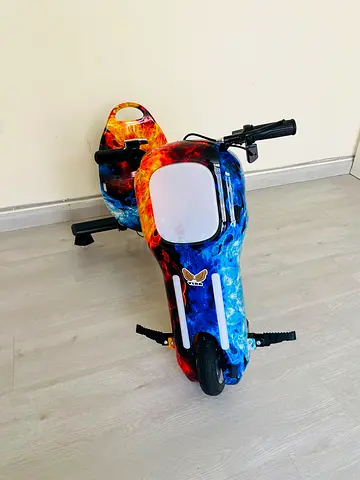 Electric 3-wheel drift trike with comic art blue styling for outdoor riding adventures.