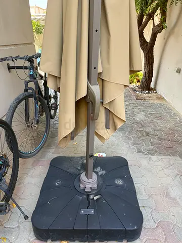 Beige outdoor patio umbrella with heavy base